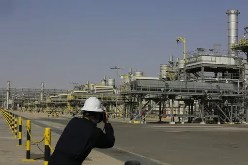 A photographer takes pictures of the Khurais oil field during a tour for journalists, 150 km east-northeast of Riyadh, Saudi Arabia, June 28, 2021. In a statement on Monday, March 21, 2022, carried by the state-run Saudi Press Agency, Saudi Arabia said it “won’t bear any responsibility for any shortage in oil supplies to global markets” after attacks by Yemen’s Iran-backed Houthi rebels have affected the kingdom’s production. (AP Photo/Amr Nabil, File)