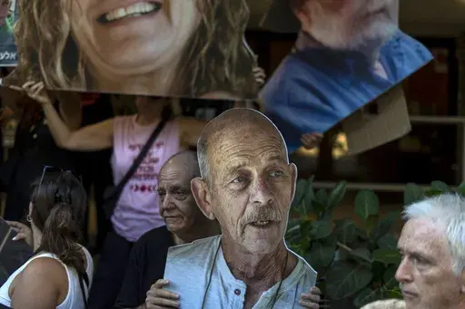 Relatives and supporters of Israeli hostages taken by Hamas in Gaza hold photos of their loved ones, including Haim Peri, center, during a protest calling for their return in Tel Aviv, Thursday, Aug. 15, 2024. (AP Photo/Ariel Schalit)