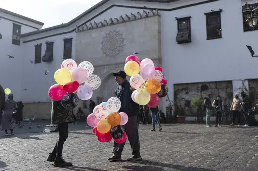 Balloon sellers wait for customers near Al-Hamidiyeh Souq on New Years Eve, in Damascus, Syria, Tuesday, Dec. 31, 2024. (AP Photo/Mosa'ab Elshamy)
