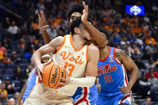 Tennessee forward Olivier Nkamhoua (13) runs into the arm of Mississippi forward Jaemyn Brakefield during the second half of an NCAA college basketball game in the second round of the Southeastern Conference tournament, Thursday, March 9, 2023, in Nashville, Tenn. Tennessee won 70-55. (AP Photo/John Amis)