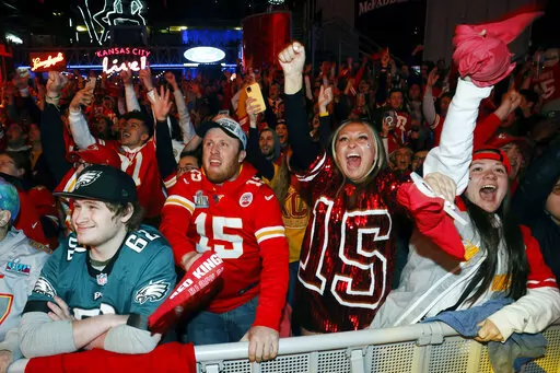 A Philadelphia Eagles fan, left, reacts as Kansas City fans celebrate a Chiefs touchdown during the NFL Super Bowl 57 football game at a watch party in the Power and Light entertainment district in Kansas City, Mo., Sunday, Feb. 12, 2023. (AP Photo/Colin E. Braley)