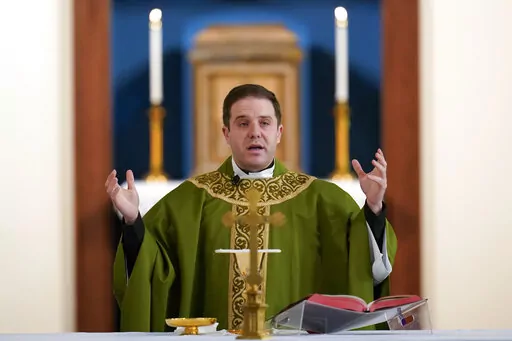 Father Matthew Hood celebrates mass at Our Lady of the Rosary church Friday, Feb. 18, 2022, in Detroit. In 2020, one word caught the ear of a young Detroit-area Catholic priest while he watched a video of his baptism from decades earlier. "Wait," the Rev. Matthew Hood recalled thinking. "Something doesn't seem right here." Indeed, an error by a deacon had spoiled the sacrament — and, in domino-like fashion, meant he truly wasn't a priest. (AP Photo/Paul Sancya)