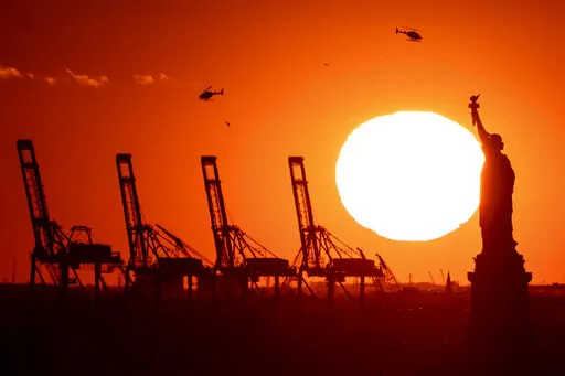 Container cranes at a port in New Jersey appear behind the Statue of Liberty, Sunday, Nov. 20, 2022, in New York. The global economy will come "perilously close" to a recession this year, led by weaker growth in all the world's top economies — the United States, Europe and China — the World Bank warned Tuesday.(AP Photo/Julia Nikhinson, File)