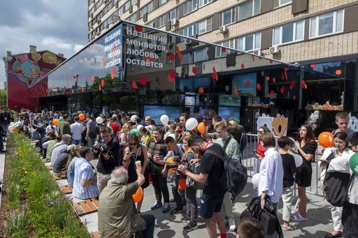 People lineup to visit a newly opened fast food restaurant in a former McDonald's outlet in Bolshaya Bronnaya Street in Moscow, Russia, Sunday, June 12, 2022. The sign reads 'The Name Changes, Love Remains'. The first of former McDonald's restaurants is reopened with new branding in Moscow. The corporation sold its branches in Russia to one of its local licensees after Russia sent tens of thousands of troops into Ukraine. (AP Photo/Dmitry Serebryakov)
