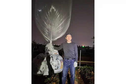 Park Sang-hak, a North Korean defector-turned-activist, prepares to release a balloon bearing leaflets at the border town of Gimpo, South Korea, on April 25, 2022. The South Korean activist said Thursday, April 28, he launched a million propaganda leaflets by balloon into North Korea this week, in his first such campaign while standing trial for past leafleting under a contentious new law that criminalizes such actions.(Courtesy of Fighters For A Free North Korea via AP)