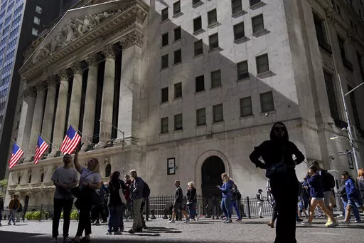 Visitors to the financial district walk past the New York Stock Exchange, Friday, Sept. 23, 2022, in New York. After sweeping through battles in statehouses across the country, the war against what's called ESG investing is heating up in Congress. (AP Photo/Mary Altaffer, File)