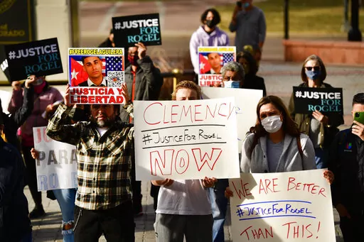 People hold signs in support of truck driver Rogel Aguilera-Mederos during a rally on the west steps of the state capitol Wednesday, Dec. 22, 2021 in Denver. Relatives, lawmakers and other supporters of a trucker sentenced to 110 years in prison after an explosive brake-failure accident that left four people dead rallied in Denver to plead for clemency. (Helen H. Richardson/The Denver Post via AP)