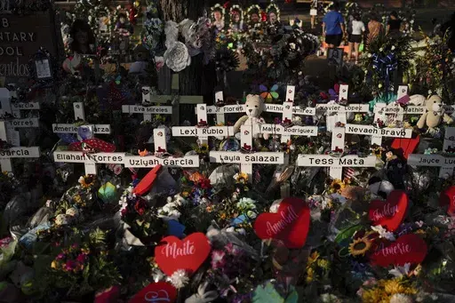 Flowers are piled around crosses with the names of the victims killed in a school shooting as people visit a memorial at Robb Elementary School to pay their respects May 31, 2022, in Uvalde, Texas. For the first time since the Uvalde school massacre, Texas Republican lawmakers on Tuesday, April 18, 2023, allowed proposals for stricter gun laws to get a hearing in the state Capitol — even though new restrictions have almost no chance of passing. (AP Photo/Jae C. Hong, File)
