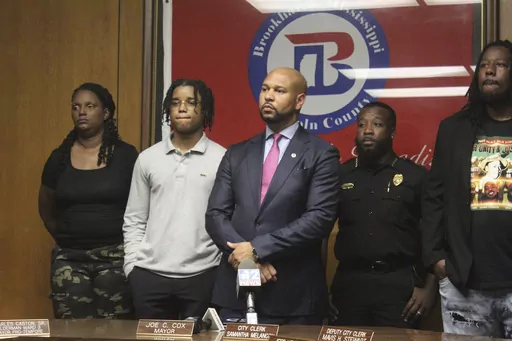 D'Monterrio Gibson, second from left, stands with his attorney Carlos Moore, center, at a press conference before jury selection in Lincoln County Circuit Court, Tuesday, Aug. 15, 2023, in Brookhaven, Miss. Gibson, a FedEx driver, was allegedly shot at by Gregory Case and his son Brandon Case. The Cases were later arrested and indicted by a grand jury for attempted murder, conspiracy of murder and shooting into a moving vehicle. (Hunter Cloud/The Daily Leader via AP)