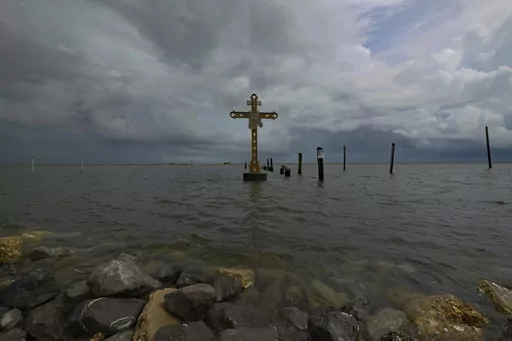 A cross erected on Shell Beach as a memorial to the residents in St. Bernard Parish, La. who died after Hurricane Katrina in 2005 is visible before Hurricane Ida makes landfall in New Orleans, Aug. 28, 2021. Hurricanes in the U.S. over last few decades killed thousands more people than meteorologists traditionally calculate and a disproportionate number of those victims are poor, vulnerable and minorities, according to a new epidemiological study released Wednesday, Aug. 16, 2023. (AP Photo/Matt