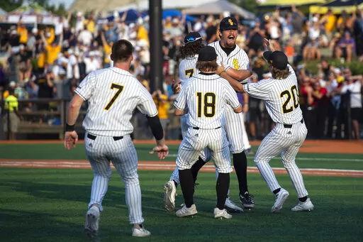 Southern Miss pitcher Tyler Stuart is embraced by his teammates as Southern Miss defeated LSU after an NCAA college baseball tournament regional game, Monday, June 6, 2022 in Hattiesburg, Miss. (Hannah Ruhoff/The Sun Herald via AP)