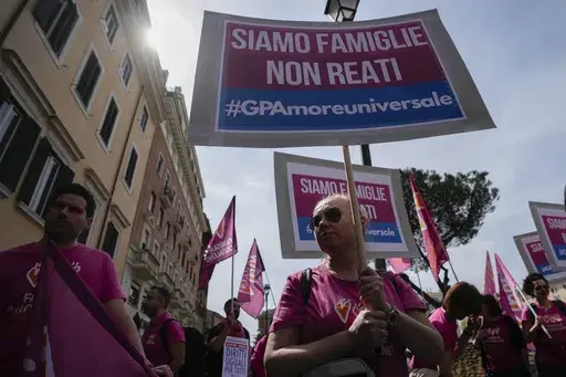People hold banners reading "we are families not crimes" during a pro-surrogacy flash-mob in Rome, April 5, 2024. (AP Photo/Alessandra Tarantino, File)