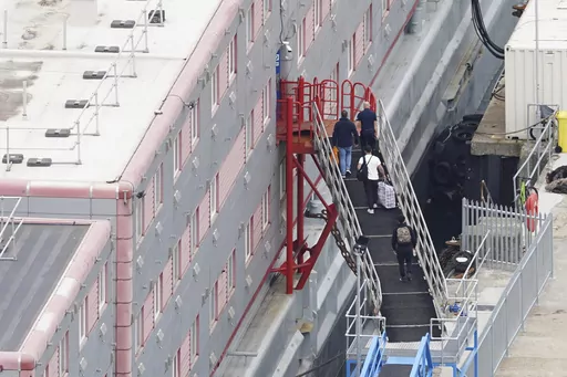 People board the Bibby Stockholm accommodation barge at Portland Port in Dorset, England, Monday, Aug. 7, 2023. A small group of asylum-seekers have been moved to a barge moored in southern England as the government tries to cut the cost of sheltering a rising number of people arriving in the country. British news media reported Monday that the asylum-seekers were transferred to the Bibby Stockholm, a barge stacked with temporary accommodations block that will ultimately house up to 500 men. (Ja