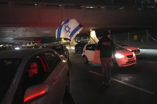 Relatives of hostages, held by Hamas in the Gaza Strip, block a highway in Tel Aviv, Monday, Feb. 10, 2025 after the militant group announced it would delay hostage releases in the Gaza Strip after accusing Israel of violating a fragile ceasefire. (AP Photo/Ohad Zwigenberg)