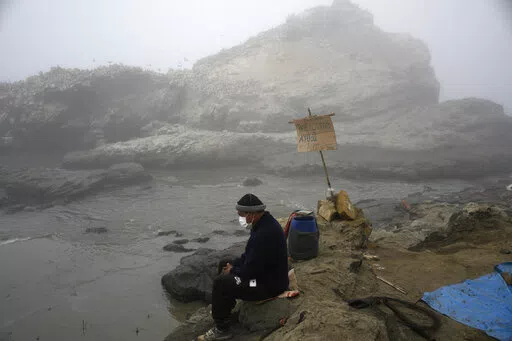 Fisherman Walter de la Cruz sits on the shore of the oil-stained Cavero Beach, unable to fish after a spill in the Ventanilla district of Callao, Peru, Jan. 21, 2022. De la Cruz, 60, is one of more than 2,500 fishermen whose livelihoods have been cast into doubt as a result of a large crude-oil spill by the Spanish-owned Repsol oil refinery on Jan. 15. (AP Photo/Martin Mejia, File)