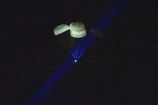 The capsule of the SpaceX Dragon Endurance spacecraft, slowed by parachutes, approaches the surface of the waters of the Gulf of Mexico off Tampa, Fla., as it returns to Earth with Expedition 68 Flight Engineers Anna Kikina of Roscosmos, Josh Cassada and Nicole Mann from NASA, and Koichi Wakata of JAXA (Japan Aerospace Exploration Agency) after a five-month mission in the International Space Station, on Saturday, March 11, 2023. (Keegan Barber/NASA via AP)