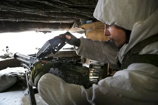 A serviceman checks his machine-gun in a shelter on the territory controlled by pro-Russian militants at frontline with Ukrainian government forces in Slavyanoserbsk, Luhansk region, eastern Ukraine, Tuesday, Jan. 25, 2022. Ukraine's leaders sought to reassure the nation that a feared invasion from neighboring Russia was not imminent, even as they acknowledged the threat is real and prepared to accept a shipment of American military equipment Tuesday to shore up their defenses. (AP Photo/Alexei 