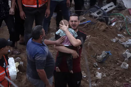 A Palestinian man cries while holding a dead child who was found under the rubble of a destroyed building following Israeli airstrikes in Nusseirat refugee camp, central Gaza Strip on Oct. 31, 2023. In just 25 days of war, more than 3,600 Palestinian children have been killed in Gaza, according to Gaza's Hamas-run Health Ministry. The advocacy group Save The Children says more children were killed in Gaza in October 2023 than in all conflict zones around the world combined in 2022. (AP Photo/Moh