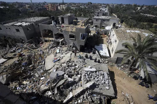 Palestinians look at destruction after an Israeli airstrike on a residential building of the Ganan family in Deir al Balah, Gaza Strip, Thursday, March 7, 2024. (AP Photo/Adel Hana)
