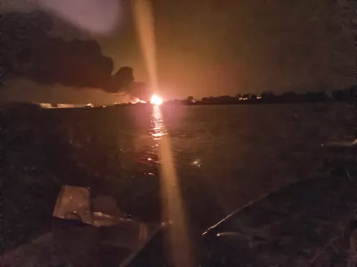 A fireball lights the horizon on the Ukrainian shore of the Danube, seen from Chilia Veche in eastern Romania on the night of Tuesday, Sept. 5, 2023. The discovery of drone debris on Romanian territory this week has left some local residents fearing that the war in neighboring Ukraine could spread into their country, as Russian forces bombard Ukrainian ports just across the Danube River from NATO-member Romania. (Mircea Franc via AP)