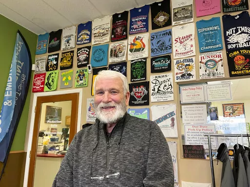 Wayne Holly, the owner of Rio Rancho T-Shirts, poses for a portrait at the family-owned shop in Rio Rancho, N.M., Monday, March 21, 2022. Holly said the small business he and his wife have operated for more than 20 years is feeling the pinch of inflation and that tax rebates offered by state governments won't be enough to combat rising prices or ongoing economic fallout from the coronavirus pandemic. (AP Photo/Susan Montoya Bryan)