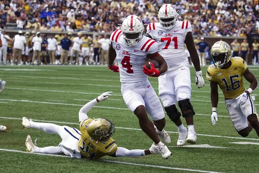 Mississippi running back Quinshon Judkins (4) gets past Georgia Tech defensive back Jaylon King (14) as he runs for a touchdown in the first half of an NCAA college football game, Saturday, Sept. 17, 2022, in Atlanta. (AP Photo/John Bazemore)