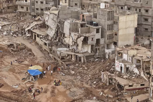 Rescuers and relatives of victims set up tents in front of collapsed buildings in Derna, Libya, Monday, Sept. 18, 2023. Some 11,300 people died when two dams collapsed during Mediterranean storm Daniel last week sending a wall of water gushing through the city, according to the Red Crescent aid group. A further 10,000 people are missing, and presumed dead. (AP Photo/Muhammad J. Elalwany)