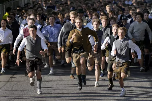 People run to enter the 188th 'Oktoberfest' beer festival in Munich, Germany, Saturday, Sept. 16, 2023. (AP Photo/Matthias Schrader)