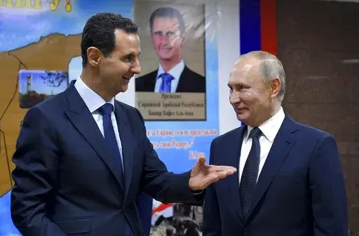 Syrian President Bashar Assad, left, gestures while speaking to Russian President Vladimir Putin during their meeting in Damascus, Syria, Jan. 7, 2020. The next chapter of the war in Ukraine could see Russia bringing in greater numbers of battle-hardened fighters from Syria, observers say. (Alexei Druzhinin, Sputnik, Kremlin Pool Photo via AP, File)