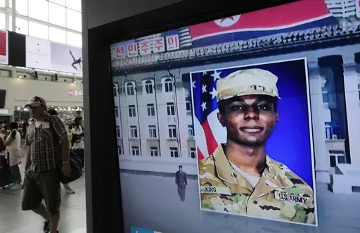 A television screen shows a file image of Pvt. Travis King during a news program at the Seoul Railway Station in Seoul, South Korea Aug. 16, 2023. King, who fled to North Korea just over a year ago, will plead guilty to desertion and four other charges and take responsibility for his conduct. (AP Photo/Ahn Young-joon, File)