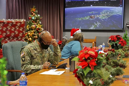 In this photo released by the U.S. Department of Defense, volunteers answer phones and emails from children around the globe during annual NORAD Tracks Santa event at Peterson Air Force Base in Colorado Springs, Colo., on Dec. 24, 2021. The U.S. military agency known for tracking Santa Claus as he delivers presents on Christmas Eve doesn't expect COVID-19 or the "bomb cyclone" hitting North America to impact Saint Nick's global travels this year. NORAD, the North American Aerospace Defense Comma