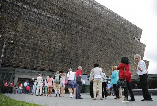 FILE- People wait in line to enter the Smithsonian National Museum of African American History and Cultural on the National Mall in Washington, Mat 1, 2017. (AP Photo/Pablo Martinez Monsivais, File)