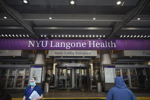 Health care workers walk in and out of the entrance at NYU-Langone Hospital on Monday, Dec. 14, 2020, in New York. A nurse was fired by the hospital after she referred to Israel's war in Gaza as "genocide" during a speech accepting an award. Labor and delivery nurse Hesen Jabr, who is Palestinian American, was being honored by NYU Langone Health for her compassion in caring for mothers who had lost babies when she drew a link between her work and the suffering of mothers in Gaza. (AP Photo/Kevin