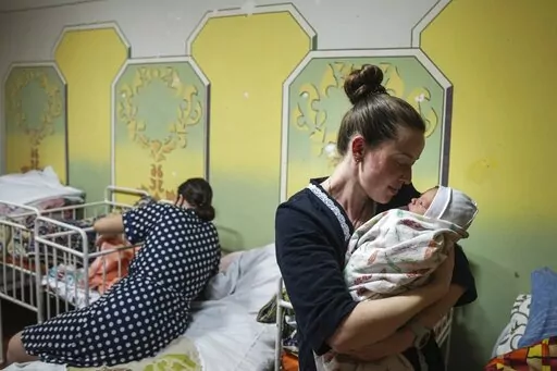 Kateryna Suharokova holds her newborn son Makar in the basement of a maternity hospital converted into a medical ward and used as a bomb shelter in Mariupol, Ukraine, Monday, Feb. 28, 2022. In makeshift shelters and underground railway platforms across Ukraine, families trying to protect the young and old and make conditions bearable amid the bullets, missiles and shells outside. (AP Photo/Evgeniy Maloletka)