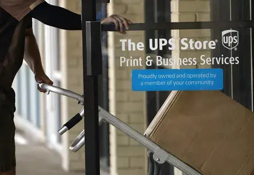 A UPS driver enters a United Parcel Service store with packages in Jackson, Miss., Monday, July 26, 2021.  With enough time and the right tools, online clothing resale can become a profitable side gig or even a full-time job. But before you start selling online, factor in recurring costs such as shipping labels, storage and fees from the resale app and payment processor you use. Other factors like communicating with buyers, taking high-quality photos and promoting your items on social media can 