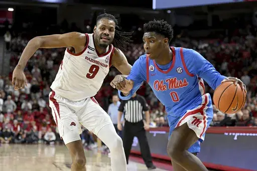 Mississippi forward Malik Dia (0) tries to drive past Arkansas forward Jonas Aidoo (9) during the first half of an NCAA college basketball game, Wednesday, Jan. 8, 2025, in Fayetteville, Ark. (AP Photo/Michael Woods)