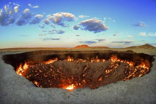 The crater fire named "Gates of Hell" is seen near Darvaza, Turkmenistan, Saturday, July 11, 2020. The president of Turkmenistan is calling for an end to one of the country's most notable but infernal sights — the blazing desert natural gas crater widely referred to as the “Gates of Hell.” The crater, about 260 kilometers (160 miles) north of the capital Ashgabat, has been on fire for decades and is a popular sight for the small number of tourists who come to Turkmenistan, which is difficu