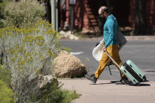 A guest leaves Bright Angel Lodge, Thursday, Aug. 29, 2024, in Grand Canyon, Ariz. (AP Photo/Matt York)