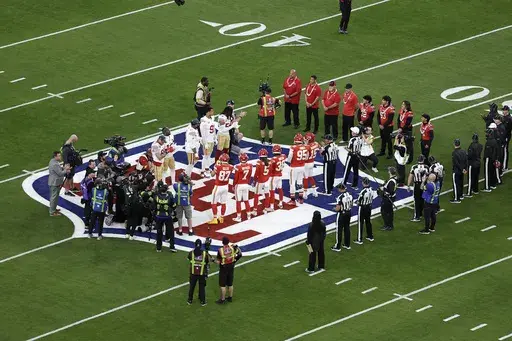 Members of the Lahainaluna High School football team, including Morgan "Bula" Montgomery (63), in red jersey third from right, watch the coin toss between the San Francisco 49ers and the Kansas City Chiefs before the NFL Super Bowl 58 football game Sunday, Feb. 11, 2024, in Las Vegas. The game was one of just a handful of times Montgomery left Maui. (AP Photo/Adam Hunger, File)