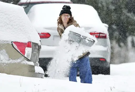 Elijah Minahan, of Johnstown, Pa., shovels out the driveway at his home in Westmont Borough as cold temperatures and snowfall hits the region on Friday, January 3, 2025. (Thomas Slusser/The Tribune-Democrat via AP)