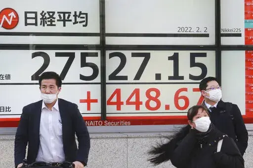 People walk by an electronic stock board of a securities firm in Tokyo, Wednesday, Feb. 2, 2022. Stock prices in Tokyo and Sydney followed Wall Street higher Wednesday while China, South Korea and Southeast Asian markets were closed for the Lunar New Year. (AP Photo/Koji Sasahara)