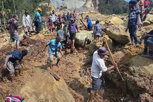CORRECTS TO YAMBALI FOR LOCATION, NOT POGERA - Villagers search through a landslide in Yambali, in the Highlands of Papua New Guinea, Sunday, May 26, 2024. The International Organization for Migration feared Sunday the death toll from a massive landslide is much worse than what authorities initially estimated. (Mohamud Omer/International Organization for Migration via AP)