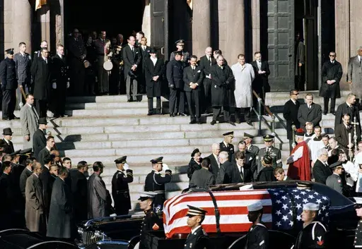 A general view outside St. Matthew's Cathedral in Washington, D.C., during President John F. Kennedy's funeral, with flag-draped coffin in the foreground, Nov. 25, 1963. The president's brothers can be seen behind the casket. At left is Sen. Edward M. Kennedy (D-Mass.), and at right entering limousine is Attorney General Robert F. Kennedy. (AP Photo, File)