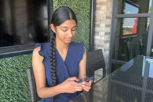 Shreya Nallamothu looks at her phone in Bloomington, Ill., on Tuesday, May 9, 2023. Illinois lawmakers aim to make their state what they say will be the first in the country to create protections for child social media influencers. Nallamothu, 15, raised her concerns to Illinois state Sen. David Koehler of Peoria, who then set the legislation in motion. (AP Photo/Claire Savage)