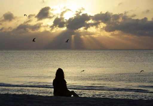 A woman meditates on the beach in Miami Beach, Fla., on Wednesday, April 28, 2010. According to a study published Wednesday, Nov. 9, 2022 in the journal JAMA Psychiatry, mindfulness meditation worked as well as a standard drug for treating anxiety in the first head-to-head comparison. (AP Photo/Lynne Sladky, File)