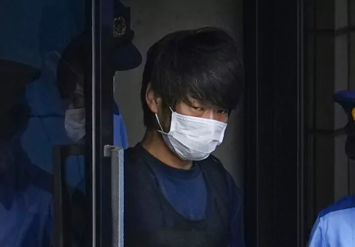 Tetsuya Yamagami, the alleged assassin of former Japanese Prime Minister Shinzo Abe, gets out of a police station in Nara, western Japan, on July 10, 2022, on his way to local prosecutors' office. A glimpse of Yamagami's painful childhood has led to a surprising amount of sympathy in Japan, where three decades of economic malaise and social disparity have left many feeling isolated and unease. (Nobuki Ito/Kyodo News via AP, File)