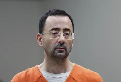 Disgraced former sports doctor Larry Nassar appears in court for a plea hearing, Nov. 22, 2017, in Lansing, Mich. Nassar was stabbed Sunday, July 9, 2023, in his cell at a federal penitentiary in Florida, out of view of surveillance cameras pointed at common areas and corridors. It’s the second time the ex-U.S. women’s gymnastics team doctor has been assaulted in federal custody while serving decades in prison for sexually abusing athletes. (AP Photo/Paul Sancya, File)