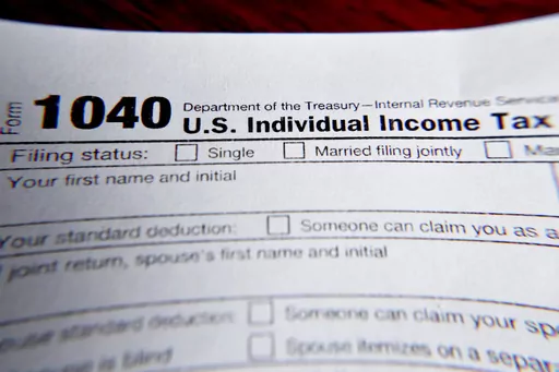 This Feb. 13, 2019 file photo shows part of a 1040 federal tax form printed from the Internal Revenue Service website, in Zelienople, Pa. It’s the first quarter of the year, and many people may be interested in starting side hustles for extra income or to finally pursue their entrepreneurial dreams. Whatever the motivation, it’s important to know the implications of starting a side gig while having a 9-to-5 job. This includes understanding how to plan for taxes, budgeting for your side incom