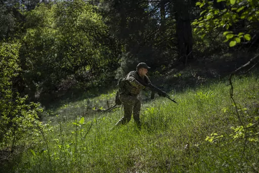 A Ukrainian Border Guard soldier participates in a military exercise in central Ukraine, Monday, May 1, 2023. Ahead of the much-anticipated Ukrainian counter-offensive, newly formed military assault units train in the country's dense forests. (AP Photo/Bernat Armangue)