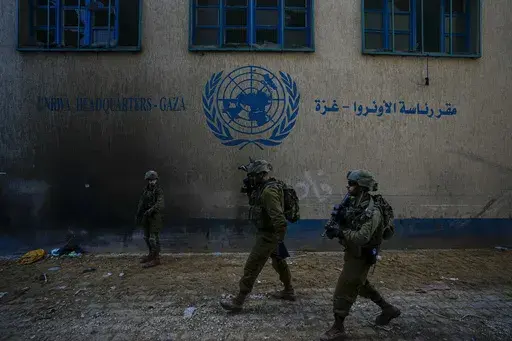Israeli soldiers take position as they enter the UNRWA headquarter where the military discovered tunnels underneath of the U.N. agency that the military says Hamas militants used to attack its forces during a ground operation in Gaza, Thursday, Feb. 8, 2024. (AP Photo/Ariel Schalit, File)